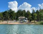 Nyrenoverad stuga med vsterlge, egen strand och brygga p Norra land